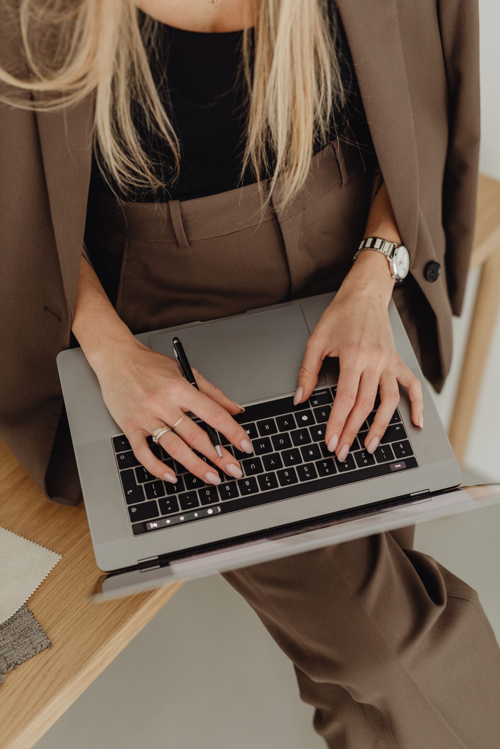 entrepreneur in brown suit holding laptop